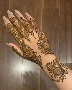 a woman's hand with henna tattoos on it