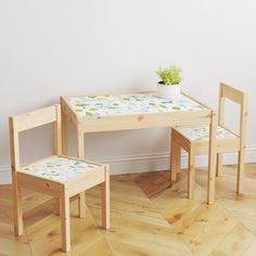 a wooden table with two chairs and a potted plant