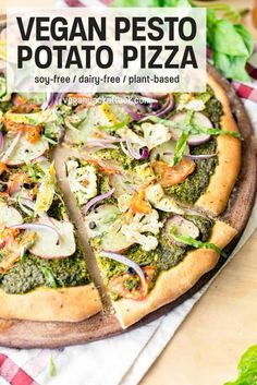 vegan pesto potato pizza with spinach and red onion on a cutting board