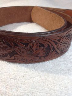 Sheridan style hand carved and tooled western belt style # 1. Includes solid brass buckle. Rustic Hand Tooled Adjustable Belt Buckles, Rustic Hand Tooled Adjustable Belts, Rustic Brown Hand-tooled Belt, Rustic Brown Hand Tooled Belt, Hand-tooled Brown Belt Buckles For Western-themed Events, Rustic Hand Tooled Belt For Western-themed Events, Traditional Hand Tooled Brown Belt, Traditional Adjustable Hand-tooled Belt, Western Style Brown Belt With Engraving