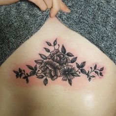 a woman's stomach with flowers and leaves on it