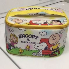 a snoopy and his friends tin lunch box on a counter with the lid open