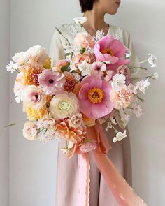 a woman holding a bouquet of flowers in her hands