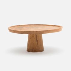 a round wooden table with two legs on the top and one leg raised to the side