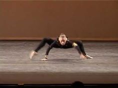 a woman is doing a handstand on the floor in front of an audience