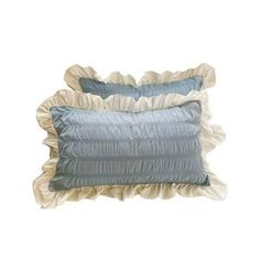 two blue and white pillows with ruffles on the bottom, one in grey