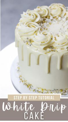 a cake with white frosting and sprinkles sitting on top of a plate