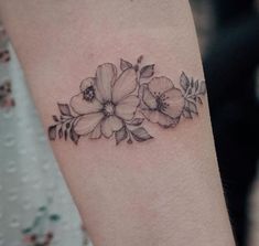 a black and white photo of flowers on the arm