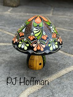 a colorfully painted mushroom sitting on top of a wooden stump with the words put hoffman above it