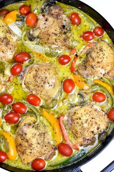 a skillet filled with chicken, tomatoes and green sauce on top of a stove