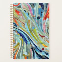 a spiral notebook with an abstract design on the front and back cover in blue, green,