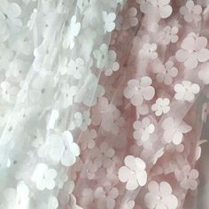 the sheer fabric has flowers on it and is white with light pink highlights in the background