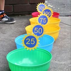 four buckets with numbers on them sitting in front of a brick wall and someone standing next to it