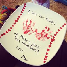 a child's hand and foot prints on a plate with the words i love you daddy