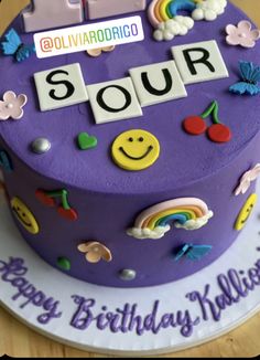 a birthday cake with the word soup spelled out in letters on top and rainbow decorations around it