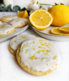 lemon cookies with white icing and oranges in the background