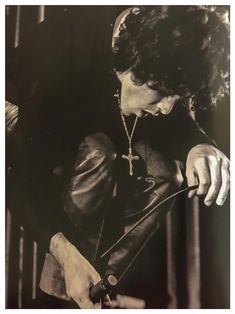 black and white photograph of a man in leather jacket looking down at his watch strap