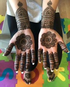 two hands with henna designs on them