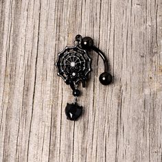 Black Gem Black Spiderweb Halloween Reversible Dangle Belly Ring If you're ready to get into the spirit of Halloween then you will love this 14 gauge navel jewelry with scary style! Made with a 3/8" black plated over 316L surgical grade stainless steel curved barbell, this reversible navel ring features a spiderweb dangle charm with a black gem spider as well as a black gem heart dangle charm that is perfect for trick or treating or a gothic ball.Specifications14 Gauge (1.6mm), 3/8" (10mm), Blac Black Piercings For Halloween Gift, Emo Pierced Jewelry For Halloween, Black Internally Threaded Belly Ring, Black Dangle Emo Jewelry, Black Metal Dangle Body Jewelry, Spooky Adjustable Black Jewelry, Black Emo Dangle Jewelry, Adjustable Black Spooky Jewelry, Adjustable Black Gothic Body Jewelry