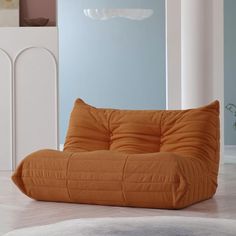 an orange bean bag chair sitting on top of a white rug in a living room