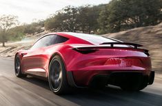 the rear end of a red sports car driving on a road with trees in the background