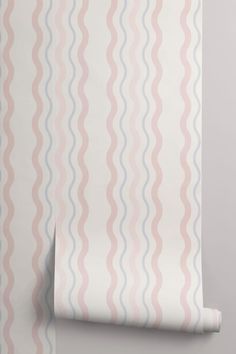 a pink and blue wallpaper with wavy lines on it's side, next to a roll of white paper