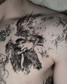 a man with tattoos on his chest is laying down