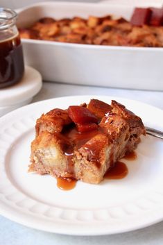 a piece of bread pudding on a plate with caramel sauce in front of it