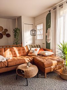 a living room filled with lots of furniture next to a window covered in sun light