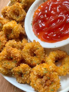 fried food on a plate with ketchup and dipping sauce