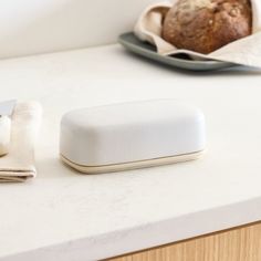 a white object sitting on top of a counter next to a loaf of bread