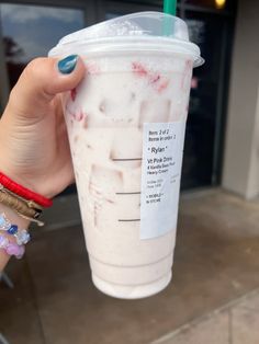 a person holding up a cup with a straw in it