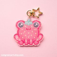 a pink frog shaped keychain with a star on it's back and eyes