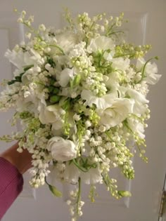 a person holding a bouquet of white flowers