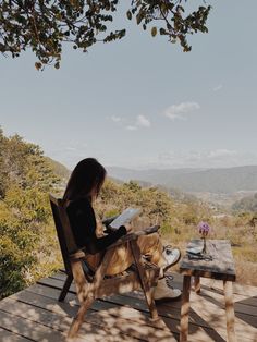 a woman sitting in a chair on top of a wooden deck