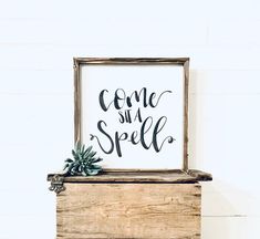 a sign that says come and spell on top of a wooden box with succulents