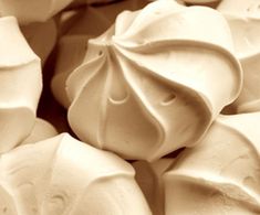 some white chocolates are piled on top of each other with icing in the middle