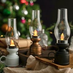 several lit candles sitting on top of a table next to christmas decorations and gifts in front of a christmas tree