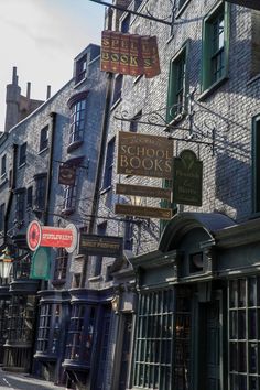 many signs are hanging from the side of buildings in an old town area, including bookshops