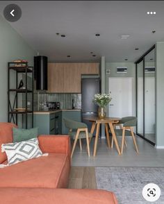 a living room filled with furniture next to a kitchen