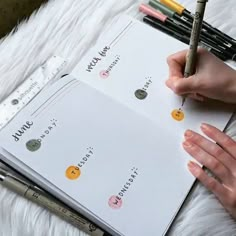 a person is writing on a notebook with markers