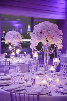 the tables are set with white flowers and candles