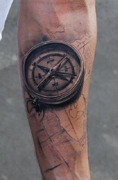 a man with a compass tattoo on his arm