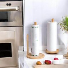 two rolls of toilet paper sitting on top of a counter next to a potted plant