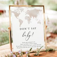 a sign that says don't say baby on it with a world map in the background