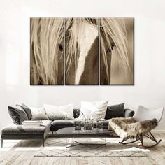 a living room scene with a couch and two horse paintings on the wall in black and white