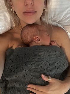 a woman laying in bed holding a baby