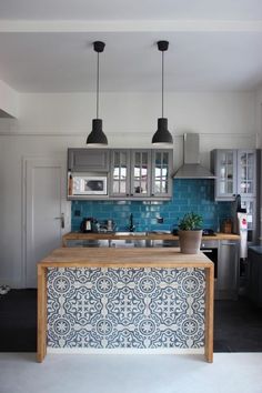 a kitchen with blue tiles and wooden counter tops