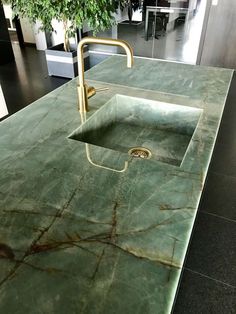 a green marble counter top with a sink and faucet in the middle is shown