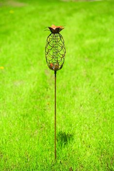 a metal sculpture on top of a green grass covered field